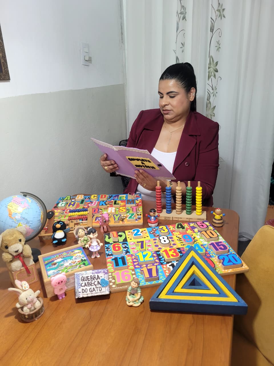 Priscila de Castro em atendimento, com materiais pedagógicos